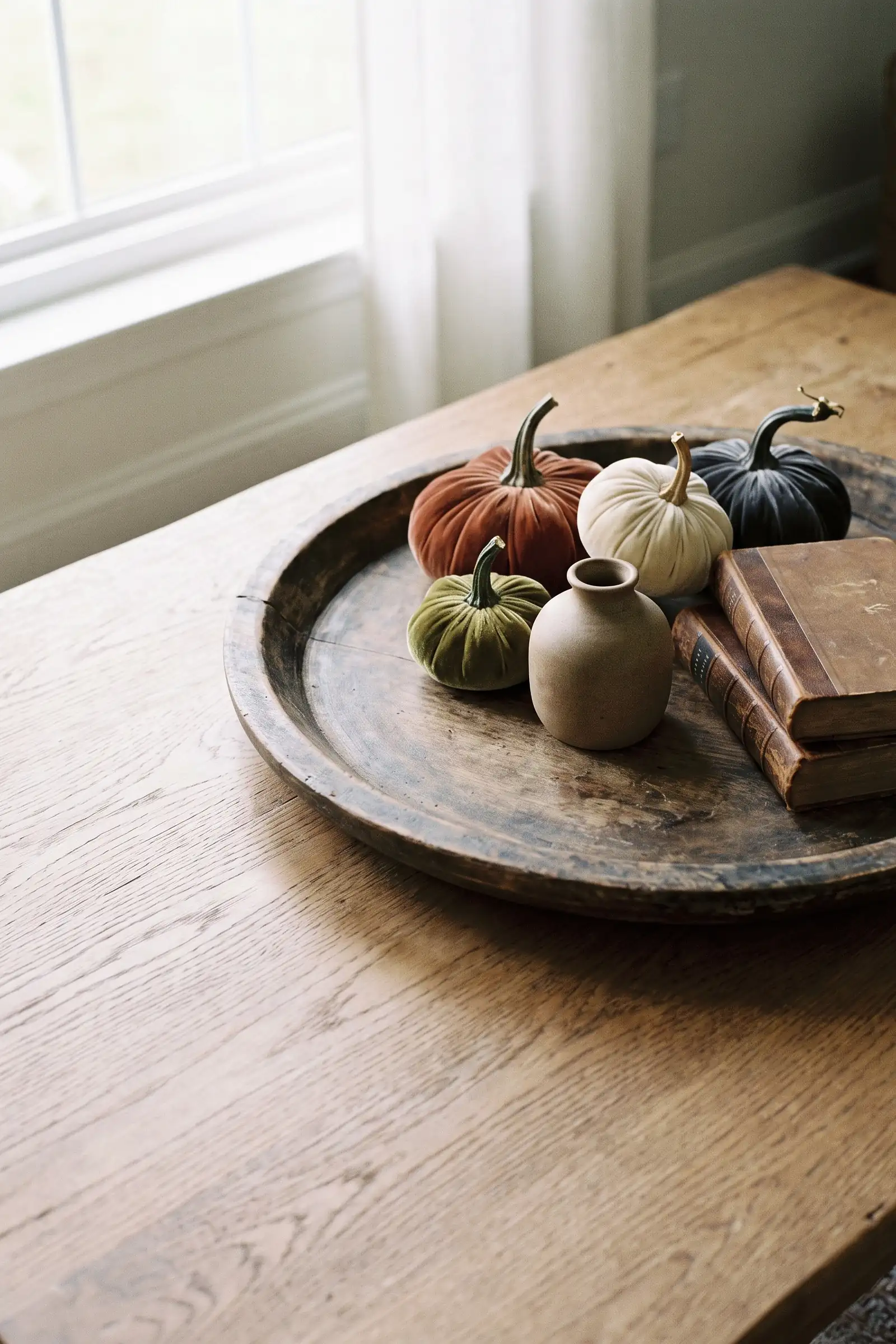 Distressed wood tray styled with muted velvet pumpkins, pottery, and natural fall texture
