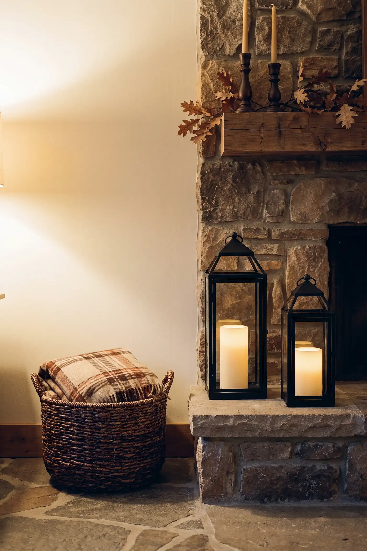 Fall hearth styled with black lanterns, flameless candles, a plaid throw, and turned wood candle holders