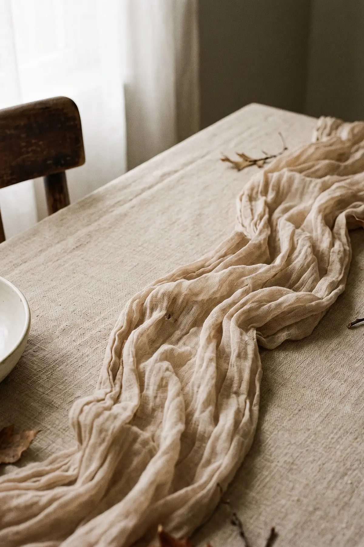 Oatmeal tablecloth layered with a softly gathered beige cheesecloth runner